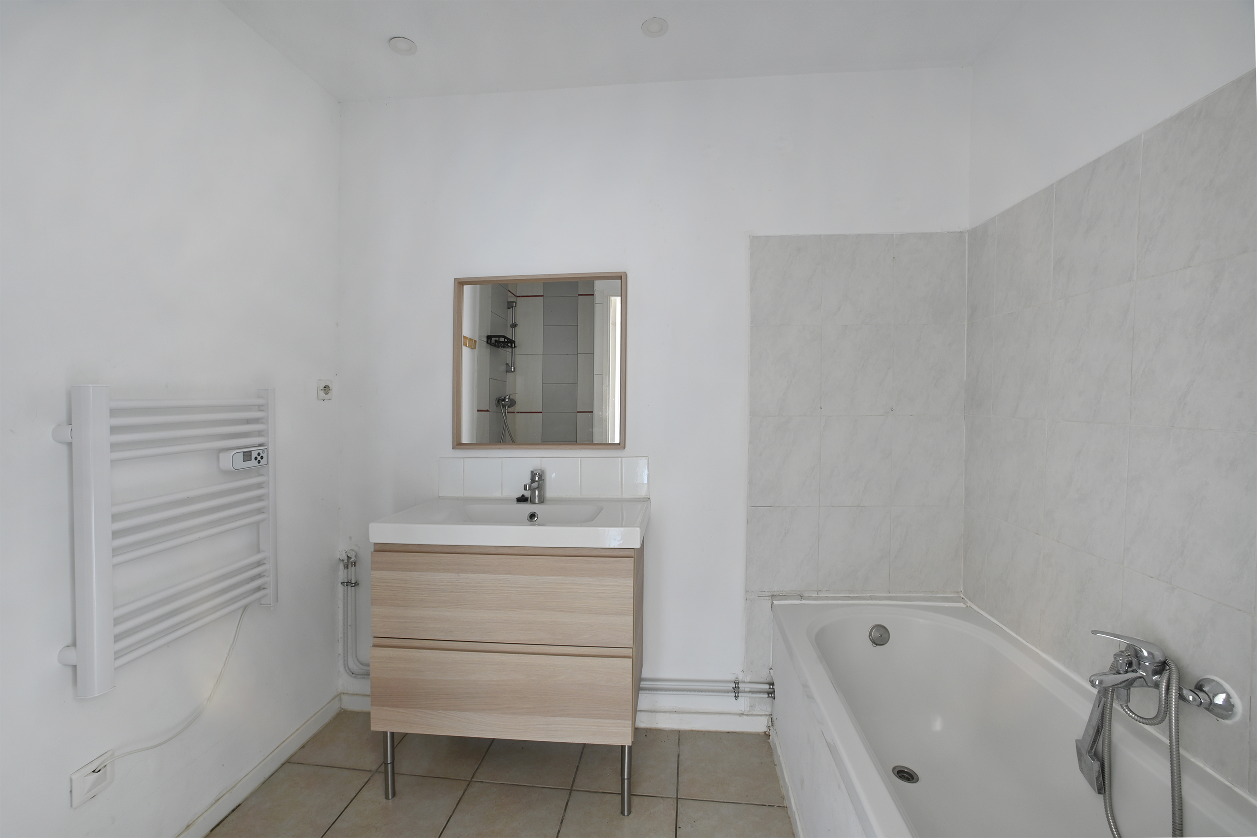 Salle de bain avec baignoire, vasque et sèche-serviettes